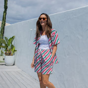 Jolly Stripe Christmas adult shirt with festive red, green, and white stripes paired with casual shorts. | Tropicool Clothing