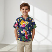 A navy blue children's shirt with a tropical floral print, including images of flowers such as hibiscus.