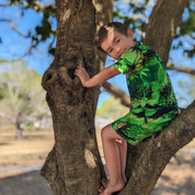 Sunset Green Kids Shirt with tropical-themed pattern; short sleeves, bright festive colors. | Tropicool Clothing